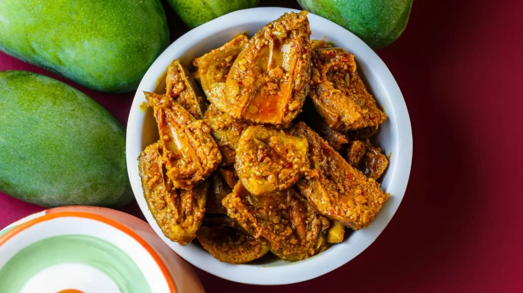 A bowl of mango pickle, a common pregnancy craving, served alongside a bowl of chutney.